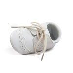 White baby shoe with laces on a white background