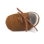 Brown baby shoe with laces on a white background