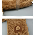 Brown plush baby onesie with a ruler for scale on a gray background