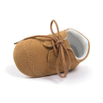 Brown baby shoe with white lining on a white background