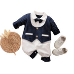 Children's formal outfit with vest, shirt, pants, and shoes on a beige surface.