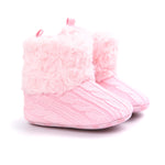 Pink baby booties with textured design on a white background
