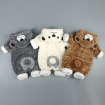 Three plush toys resembling animals in colorful outfits on a gray background