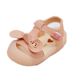 Pink baby shoe with a bow and heart design on a white background