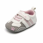 Baby shoe with pink paw print design on a white background